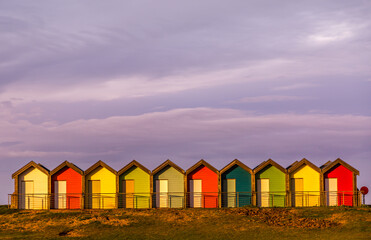 The vibrant and colorful beach huts by the promenade overlooking Blyth beach with a lovely sunset in Northumberland, England © Paul Jackson