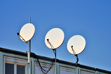 Drei Satelliten-Antennen vor blauem Himmel - obrazy, fototapety, plakaty