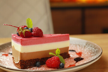 Piece of tasty mousse cake with   fresh berries on plate  