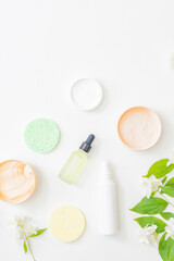 Flat lay composition with cosmetics and jasmine flowers on a light background