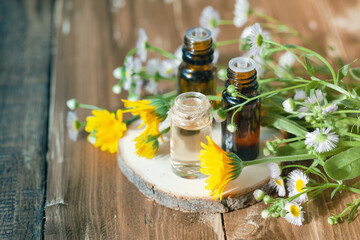 Concept of natural organic ingredients, essential oil, flower and herbal extracts in cosmetics. Aromatherapy, relaxation. Close up. Wooden background, copy space.