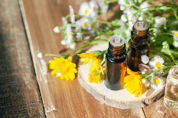 Concept of natural organic ingredients, essential oil, flower and herbal extracts in cosmetics. Aromatherapy, relaxation. Close up. Wooden background, copy space.