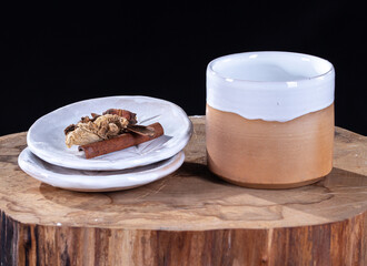 mug and saucer with sweets on a black background