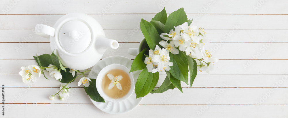 Wall mural Jasmine flowers and teapot on white wooden background. Herbal tea of jasmine flower. Flat lay.