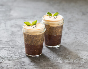 Dessert in glass, coffee chocolate chia pudding chia with cottage cheese cream, on a dark gray background