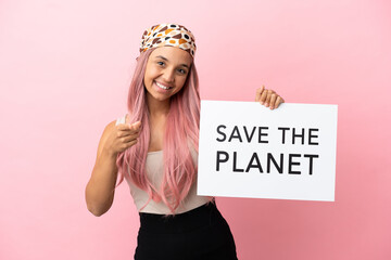 Young mixed race woman with pink hair isolated on pink background holding a placard with text Save...