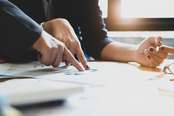 The company employee points to the budget document and makes marketing out of the budget being reviewed