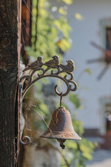 Rostige Glocke aus Metall mit Vogeldekoration