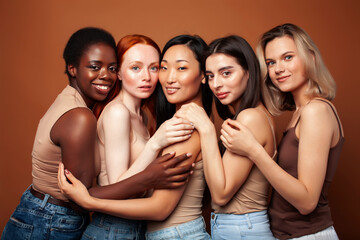 young pretty caucasian, afro, asian, scandinavian woman posing cheerful together on brown background, lifestyle diverse nationality people concept
