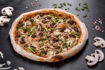 Fresh delicious Italian pizza with meat, mushrooms and tomatoes on a dark concrete background