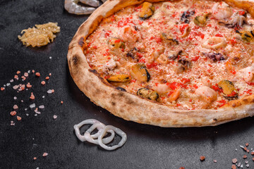 Tasty sliced pizza with seafood and tomato on black background