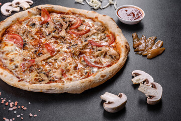 Fresh delicious Italian pizza with mushrooms and tomatoes on a dark concrete background