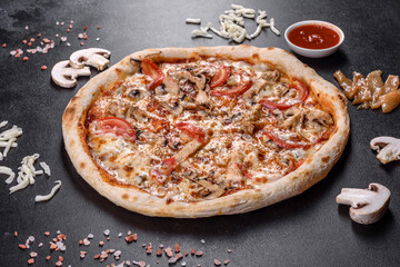 Fresh delicious Italian pizza with mushrooms and tomatoes on a dark concrete background