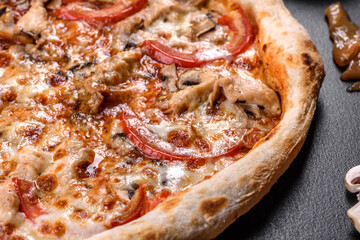 Fresh delicious Italian pizza with mushrooms and tomatoes on a dark concrete background