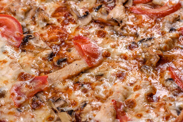 Fresh delicious Italian pizza with mushrooms and tomatoes on a dark concrete background