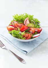 Healthy Salad with Tomatoes, Radish and Lettuce. Easy summer snack. Bright wooden background. Copy space. 
