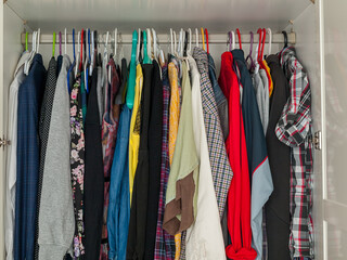 wardrobe with hanging clothes, filled wardrobe, storing clothes at home, saving space
