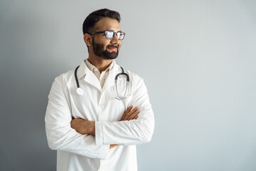 Studio portrait shot of indian doctor standing looking aside at copy space