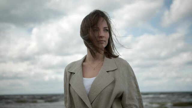 Confident woman looking into distance with wind in her hair with melancholy mood.