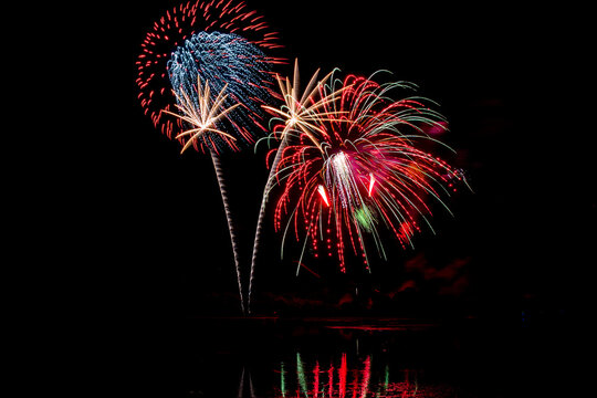 Holiday fireworks above water with reflection in the water