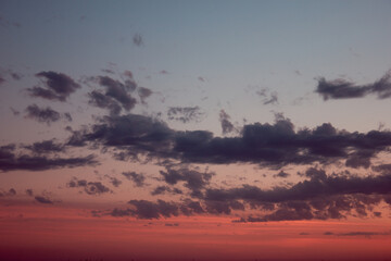 Long fluffy clouds in the evening in warm weather shimmering