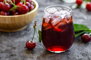 Glass of sour cherry juice with fresh red cherries, summer juice