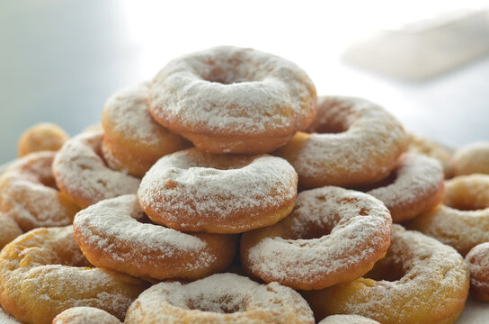 pile of donuts with powdered sugar topping with beautiful blurred background