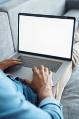 Closeup back view on laptop white empty blank mock up screen with male hand on keyboard. Man enjoy online shopping, booking travel vacation, remote work, e-learning or distance education. Vertical 