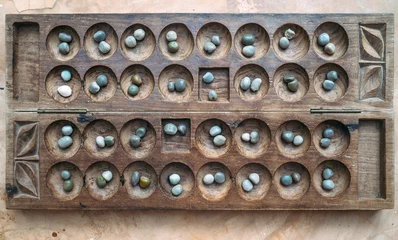 Keuken spatwand met foto Antique Boa Mancala tradition African Board Game. Vintage Bao carved wooden Board Game. With natural baobab tree seeds Balls. © Soloviova Liudmyla