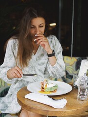 
young woman eating in a cafe on the veranda in summer