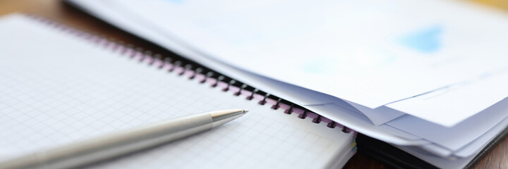 Pen with notebook and documents are on table