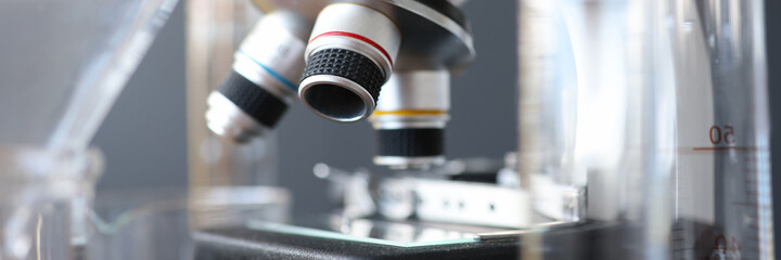 Fototapeta na wymiar Research microscope in laboratory is next to test tubes.