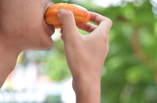 cropped man's hand eating donut