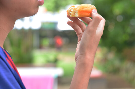 cropped man's hand eating donut