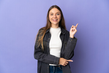 Young Lithuanian woman isolated on purple background happy and pointing up