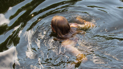 A young girl swimming on the river