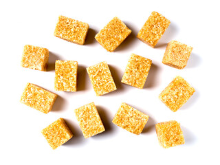 Close-up of pieces of brown cane sugar. Isolated on a white background.
