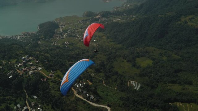 paragliding in the himalayan mountains over a lake
