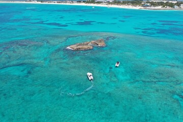Obraz premium Aerial view of boats anchored near coral rocks off North Bimini, Bahamas on sunny summer afternoon.