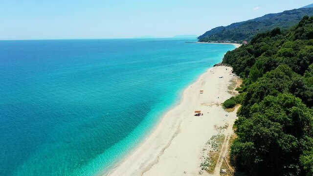Drone rising above the sandy beach in Horefto, Greece. The drone fly upwards, filming the beach. It is a sunny summer day. Drone aerial 4K stock footage