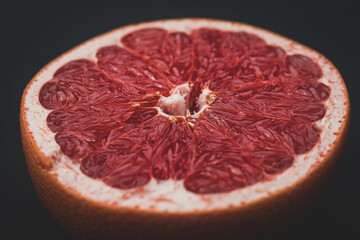 red grapefruit cut in half, still life, studio photography, fruit on a black background
