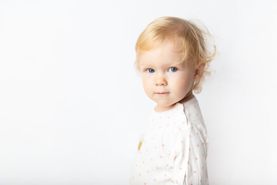 Caucasian cute curly baby girl in wearing a shirt on a white background with copy space