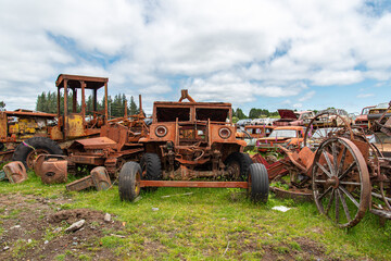 Obraz premium Antique cars on a big scrapyard at the end of Old Coach Road Trail, New Zealand