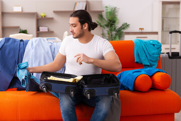 Young man student preparing for trip at home