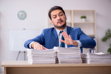 Young male employee unhappy with excessive work in the office