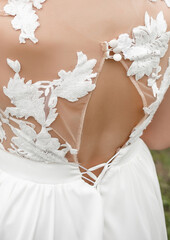 Fashionable beautiful white bride wedding dress with patterns, close-up