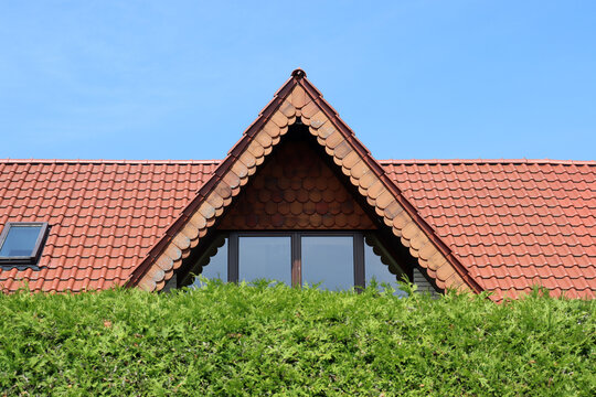 Spitzgaube mit Dach hinter einer gr&uuml;nen Hecke in Nordrhein-Westfalen, Deutschland