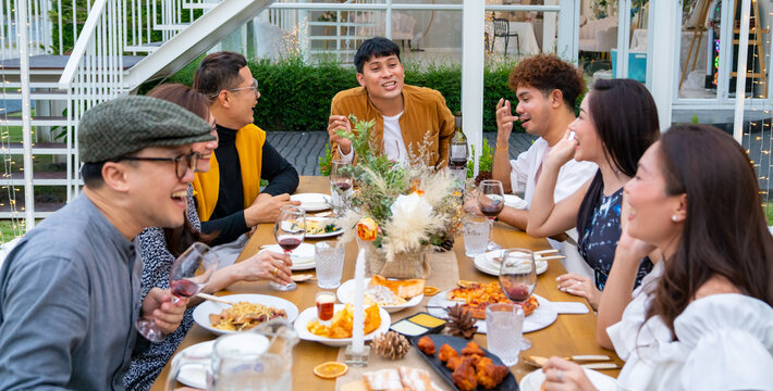 Group Of Diversity Asian Millennial People Friends Enjoy Outdoor Garden Dinner Party Eating Food And Drinking Wine With Talking Together. Reunion Friendship Meeting Celebration And Night Life Concept.