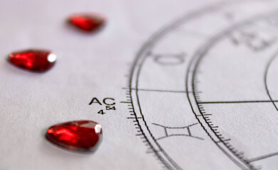 Detail of printed astrology chart with with red heart shaped sequins