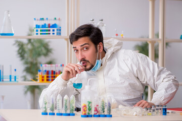 Young male chemist working at the lab during pandemic